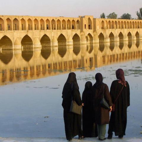 (FILES) Iranian women look at the "Si-o-Se Pol" bridge (33 arches bridge) on Zayandeh Rud river in Isfahan 13 July 2002. A young French tourist has been shot dead by a known criminal in the Iranian city of Isfahan, one of the country's main tourist draws, the Fars news agency reported 10 December 2007. AFP PHOTO/Behrouz MEHRI (Photo credit should read BEHROUZ MEHRI/AFP/Getty Images)