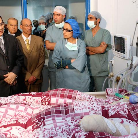 A handout picture released by the Tunisian Presidency shows Tunisian president Zine El-Abidine Ben Ali (2nd L)  looking at Mohamed Al Bouazzizi (R), during his visit at the hopital  in Ben Arous near Tunis on December 28, 2010.  Mohamed Al Bouazzizi, a 26-year-old university graduate, who was forced to sell fruit and vegetables on the streets, doused himself in petrol and set himself alight on December 17, which left him in a serious condition with severe burns.  Days of rioting in Tunisia by mostly jobless