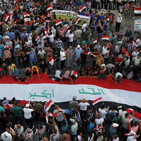 Protesters display a huge Iraqi flag during a demonstration against corruption, poor services and power cuts in Baghdad, Iraq, August 21, 2015.  REUTERS/Ahmed Saad - RTX1P48C