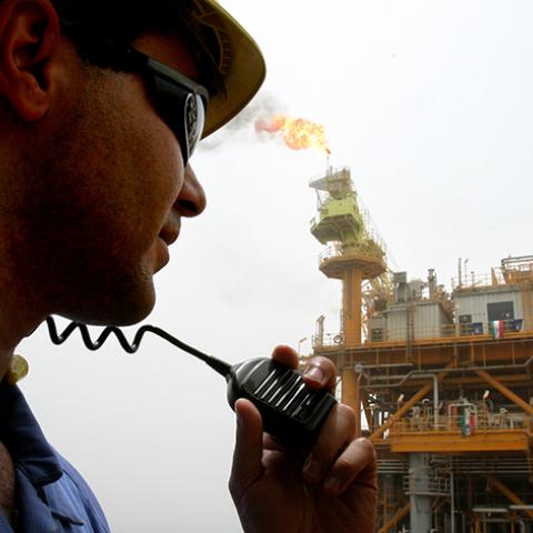 An Iranian worker speaks into a radio on an oil production platform at the Soroush oil fields in the Persian Gulf, 1,250 km (776 miles) south of the capital Tehran, July 25, 2005. Picture taken July 25, 2005. REUTERS/Raheb Homavandi  CJF/KS - RTRIU0Y