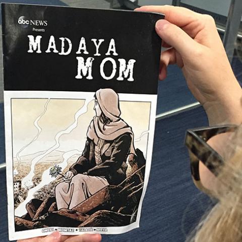 In this setup photo a woman looks at the cover of the comic book "Madaya Mom" in Washington, DC on October 7, 2016.
The book, titled "Madaya Mom," is available online for free on the ABC News website. ABC News has been in contact with a woman from the syrian town of Madaya, near the lebanese border. Madaya has been held under siege by the syrian regim army for the better part of the last two years. The woman, who's a mother of five, has sent messages to describe her everyday life. These messages were used a
