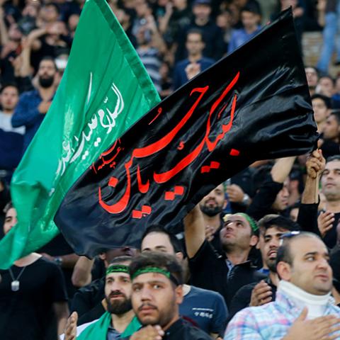 Iranian fans wave a religious banner to mark Ashura, which marks the death of Prophet Mohammed's grandson Imam Hussein in the seventh century, during the 2018 World Cup qualifying football match between Iran and South Korea at the Azadi Stadium in Tehran on October 11, 2016. / AFP / ATTA KENARE        (Photo credit should read ATTA KENARE/AFP/Getty Images)