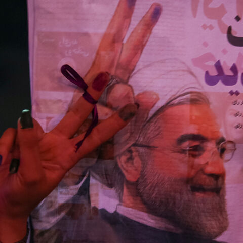 A supporter of Iranian president Hassan Rouhani holds his poster as she celebrates his victory in the presidential election, in Tehran, Iran, May 20, 2017. TIMA via REUTERS ATTENTION EDITORS - THIS IMAGE WAS PROVIDED BY A THIRD PARTY. FOR EDITORIAL USE ONLY.      TPX IMAGES OF THE DAY - RTX36RDP