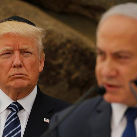 Israeli Prime Minister Benjamin Netanyahu talks on a podium as U.S. President Donald Trump listens during a ceremony commemorating the six million Jews killed by the Nazis in the Holocaust, in the Hall of Remembrance at Yad Vashem Holocaust memorial in Jerusalem May 23, 2017.  REUTERS/Jonathan Ernst - RTX376QY