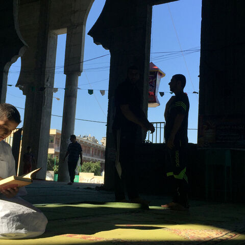 A Palestinian boy reads the Koran at a mosque in the second Friday of Muslim holy month of Ramadan, in Gaza city, June 17, 2016. REUTERS/Suhaib Salem - S1AETKLEYYAA