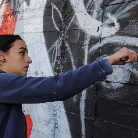 Suha Sultan, a 20-year-old graffiti artist and student, uses a brush to draw a mural on a wall in the Jordanian capital Amman on December 16, 2017.
A tiny group of graffiti artists are on a mission -- daubing flowers, faces and patterns across the capital Amman to bring more colour to the lives of its four million inhabitants.
In a conservative society like Jordan's, the graffiti artists have constantly had to challenge convention to carve out a niche for their works, though still with limits as they steer 