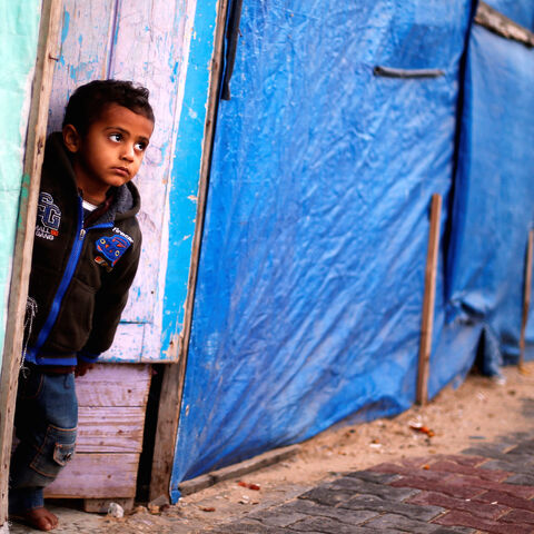 A Palestinian boy who lives in a container as a temporary replacement for his house that was destroyed in the 2014 war, looks out on a rainy day in Beit Hanoun in the northern Gaza Strip December 15, 2016.  REUTERS/Suhaib Salem - RC1DAD9F6BE0