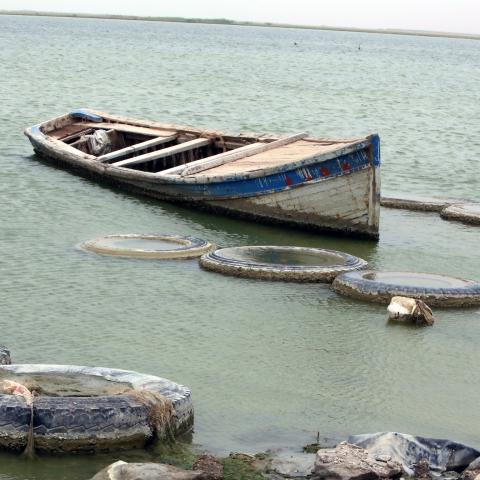 A fishing boat floats on the shores of the manmade Lake Razzaza, west of the Shiite Muslim holy city of Karbala, around 120 kilometres south of Baghdad, on May 20, 2013. For the past two weeks, most of fishermen who rely on their trade to make a living, have stopped sailing on the lake fearing that they might by targeted by gunmen coming from the mainly Sunni Muslim Anbar province where security has deteriorated. AFP PHOTO/AHMAD AL-RUBAYE        (Photo credit should read AHMAD AL-RUBAYE/AFP/Getty Images)