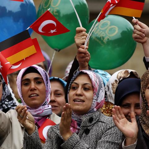 Turkish women wave German and Turkish flags during a visit of Turkey's President Abdullah Gul in Osnabrueck September 20, 2011.  REUTERS/Ina Fassbender (GERMANY - Tags: POLITICS) - BM2E79K144D01