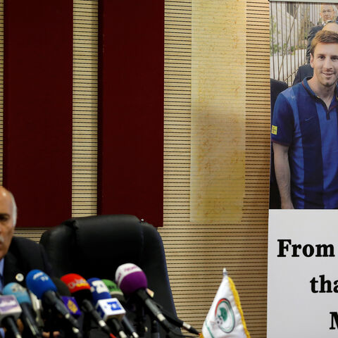 A poster of Palestinian FA chief Jibril Rajoub with Argentina's soccer player Lionel Messi is seen during Rajoub's news conference, in Ramallah in the occupied West Bank June 6, 2018. REUTERS/Mohamad Torokman - RC13B03D01D0