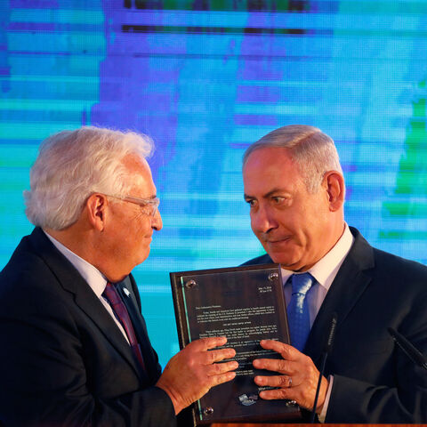 Israeli Prime Minister Benjamin Netanyahu hands U.S. Ambassador to Israel David Friedman a letter of appreciation, during a reception held at the Israeli Ministry of Foreign Affairs in Jerusalem, ahead of the moving of the U.S. embassy to Jerusalem, May 13, 2018. REUTERS/Amir Cohen - RC12C6659B00
