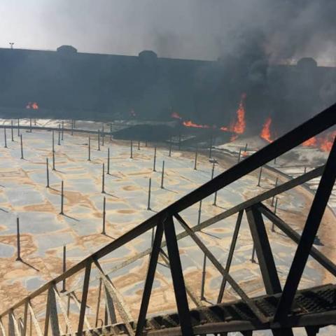 Smoke and flame rise from an oil storage tank that was set on fire amid fighting between rival factions at Ras Lanuf terminal, Libya in this handout picture released on June 16, 2018. The National Oil Corporation/ Handout via Reuters ATTENTION EDITORS - THIS PICTURE WAS PROVIDED BY A THIRD PARTY. REUTERS IS UNABLE TO INDEPENDENTLY VERIFY THIS IMAGE. - RC1597B41120