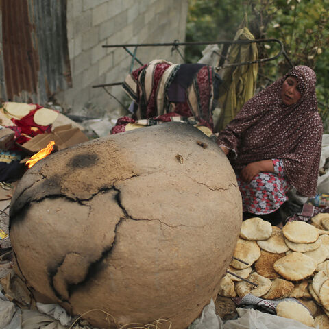 Palestinian women bake bread in a clay oven in the northern Gaza Strip May 5, 2014. REUTERS/Mohammed Salem (GAZA - Tags: SOCIETY) - GM1EA5607K501