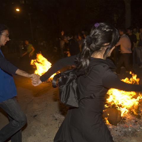 A woman dances with men during the "Chaharshanbeh Soori" festival in Tehran March 18, 2008. People jump over fire during the festival to burn away the year's sins on the last Tuesday night before the new year. REUTERS/Raheb Homavandi (IRAN) - GM1E43J07KQ01