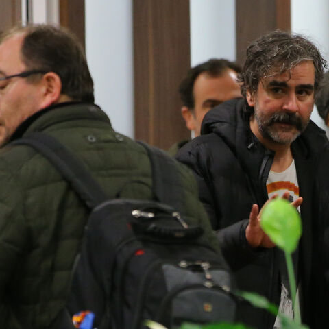 German-Turkish journalist Deniz Yucel walks through a plane as he is flanked by a group of people at Ataturk International Airport in Istanbul, Turkey, February 16, 2018. REUTERS/Huseyin Aldemir - UP1EE2G1ER906