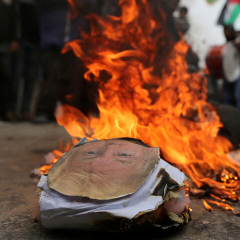 Palestinian demonstrators burn an effigy depicting U.S. President Donald Trump during a protest against U.S aid cuts, outside the United Nations' offices in the southern Gaza Strip February 11, 2018. REUTERS/Ibraheem Abu Mustafa     TPX IMAGES OF THE DAY - RC1D5F27F630