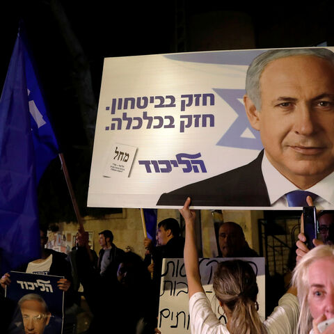 Supporters of Israeli Prime Minister Benjamin Netanyahu protest outside his residence following Israel's Attorney General Avichai Mandelblit's indictment ruling in Jerusalem November 21, 2019. The placards in Hebrew read, "Strong in security Strong in Economy ". REUTERS/Ronen Zvulun - RC2UFD9194FK