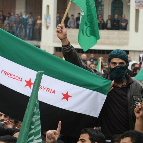 Palestinian supporters of the Islamist movement Hamas wave their flag and a pre-Baath Syrian flag (C) during a demonstration in the West Bank city of Hebron on November 21, 2012, against the ongoing Israeli military offensive on the Gaza Strip. Israel launched its offensive on November 14 with the targeted killing of a Hamas military chief. Since then, 147 Palestinians and five Israelis have been killed. AFP PHOTO/HAZEM BADER        (Photo credit should read HAZEM BADER/AFP via Getty Images)