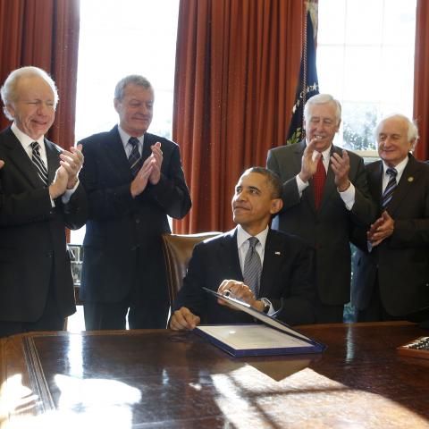 U.S. President Barack Obama (seated) signs H.R. 6156, the Russia and Moldova Jackson-Vanik Repeal and Magnitsky Rule of Law Accountability Act, in the Oval Office of the White House in Washington, December 14, 2012. From L-R are: U.S. Sen. Ben Cardin, U.S. Sen. Joe Lieberman, U.S. Sen. Max Baucus, Obama, U.S. Rep. Steny Hoyer, U.S. Rep. Sandy Levin, U.S. Rep. Jim McGovern, and U.S. Rep. Gregory Meeks.      REUTERS/Larry Downing  (UNITED STATES - Tags: POLITICS) - GM1E8CF053K01