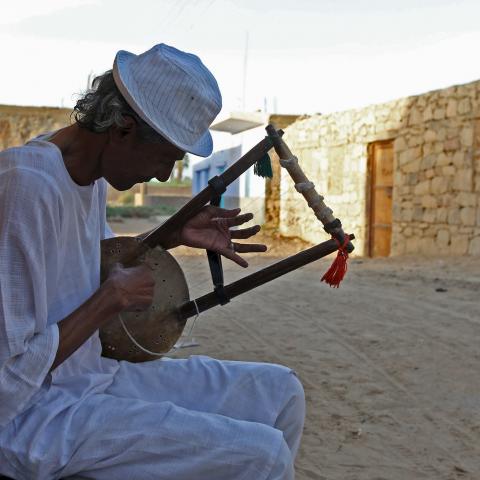 A man plays music on a traditional musical instrument in the Nubian village of Adindan near Aswan, south of Egypt, September 30, 2015.  For half a century, Egypt's Nubians have patiently lobbied the government in Cairo for a return to their homelands on the banks of the Nile, desperate to reclaim territory their ancestors first cultivated 3,000 years ago. Yet all their efforts to gain political influence have brought next to nothing. In Egypt's incoming parliament, which will be finalised after a second rou