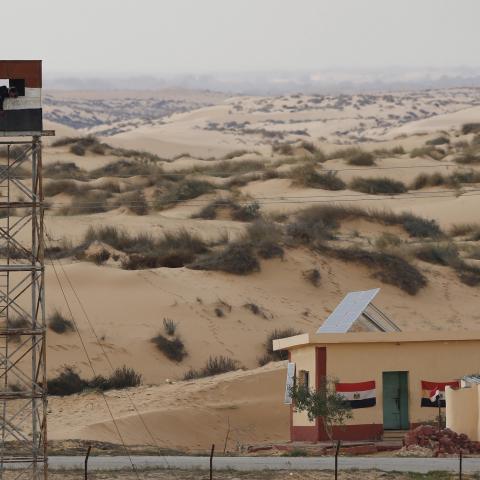 An Egyptian policeman gestures from an observation tower is seen from the Israeli side of the border with Egypt's Sinai peninsula, in Israel's Negev Desert February 10, 2016. REUTERS/Amir Cohen  - GF10000303487