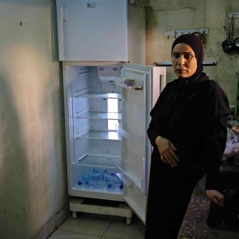 TOPSHOT - A Lebanese woman stands next to her empty refrigerator in her apartment in the port city of Tripoli north of Beirut on June 17, 2020. - Lebanon's economic crisis has led to a collapse of the local currency and purchasing power, plunging whole segments of the population into poverty as exemplified by near-empty fridges in many households. (Photo by IBRAHIM CHALHOUB / AFP) (Photo by IBRAHIM CHALHOUB/AFP via Getty Images)