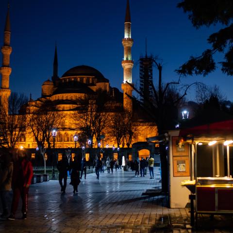 A street vendor sits in front of the Blue Mosque during the new year's celebrations in Istanbul on December 31, 2020. - Turkish government announced a four-days lockdown between December 31 and January 04, 2021. (Photo by Yasin AKGUL / AFP) (Photo by YASIN AKGUL/AFP via Getty Images)