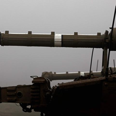 An Israeli soldier stands near a parked Merkava Mark IV battle tank near Moshav Alonei HaBashan in the Israeli-annexed Golan Heights on March 1, 2021. (Photo by Jalaa MAREY / AFP) (Photo by JALAA MAREY/AFP via Getty Images)