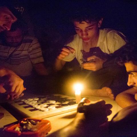 Syrian rebel fighters play a game by candle light, due to electricity cuts on May 26, 2013 in Adana, near the northeastern city of Deir Ezzor. Syria's opposition denounced as "too little, too late" an EU decision to lift an arms embargo on rebels fighting the regime of President Bashar al-Assad.  AFP PHOTO / RICARDO GARCIA VILANOVA        (Photo credit should read Ricardo Garcia Vilanova/AFP via Getty Images)