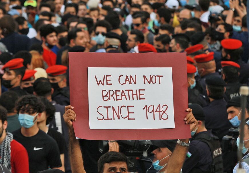 A man holds up a sign reading in English "we can not breathe since 1948" (the date of the creation of the State of Israel) during a protest to express solidarity with the Palestinian people near the Israeli embassy in Jordan's capital Amman on May 9, 2021.