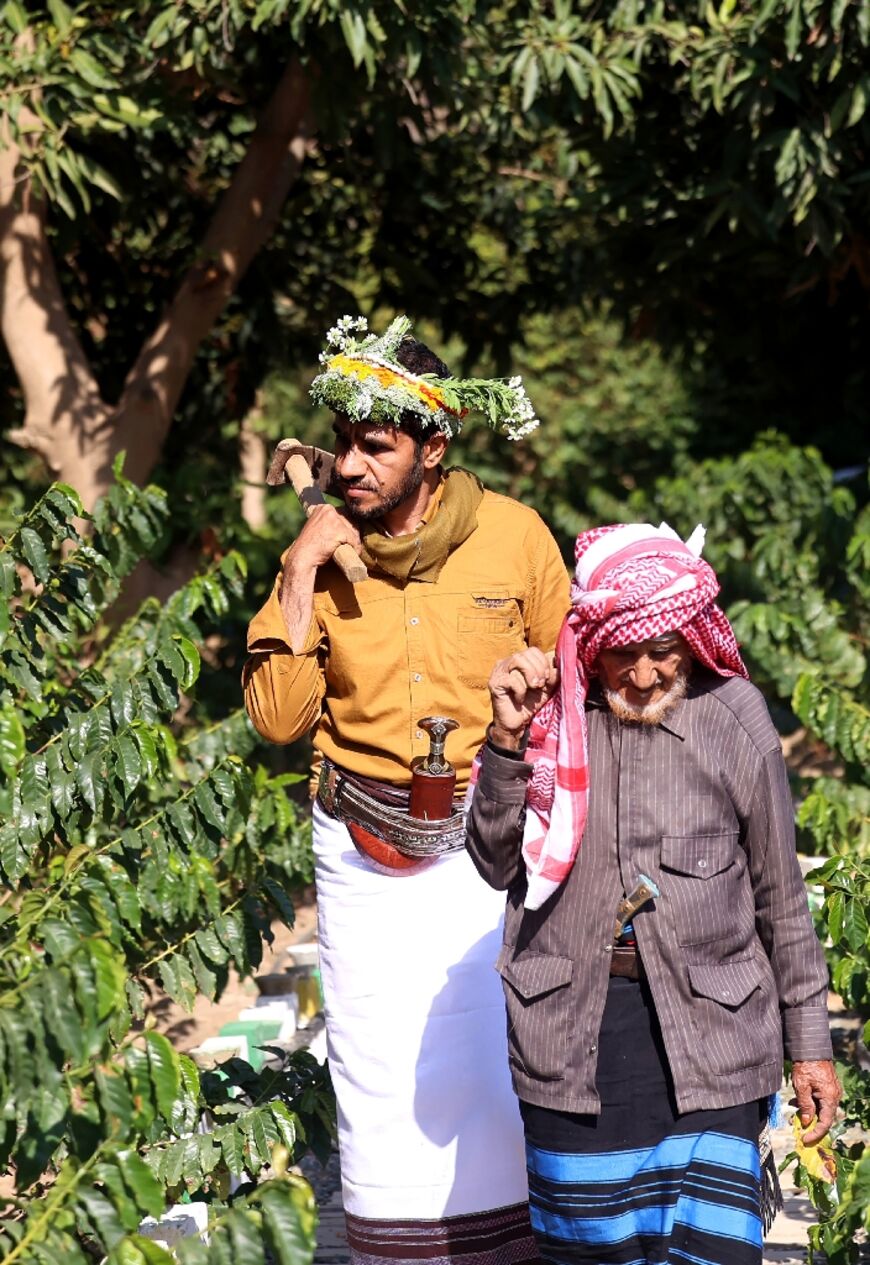 Malki and his son Ahmed, 42, wear traditional dress in the field