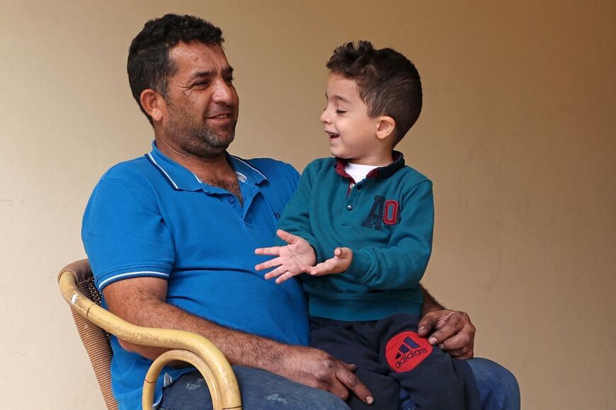 Syrian refugee Maher Ahmad, 43, sits with his child at the Saint Nicolas residential complex. More than 12,000 Syrians have sought refuge in Cyprus since 2011