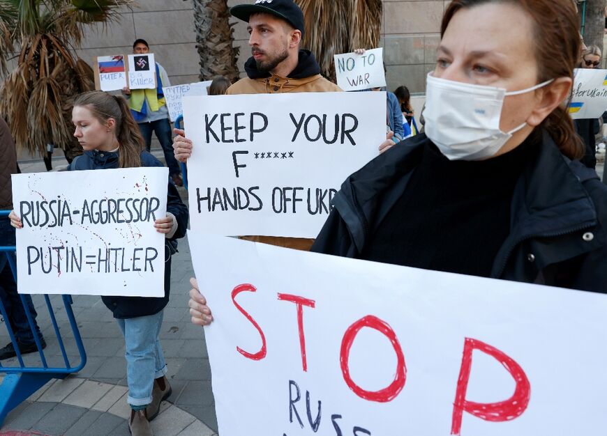 Demonstrators hold placards at the Tel Aviv protest against Russia's invasion of Ukraine on February 24, 2022