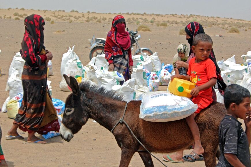 Yemeni families receive flour rations and other basic food supplies from charities in the province of Lahj, in southern Yemen, on March 29, 2022