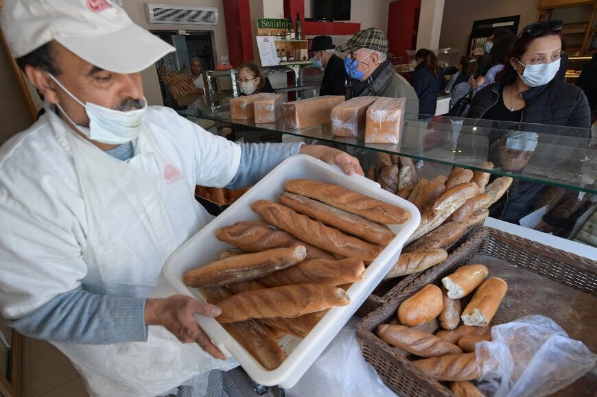A baker with fresh loaves in the El Menzah area of Tunis 