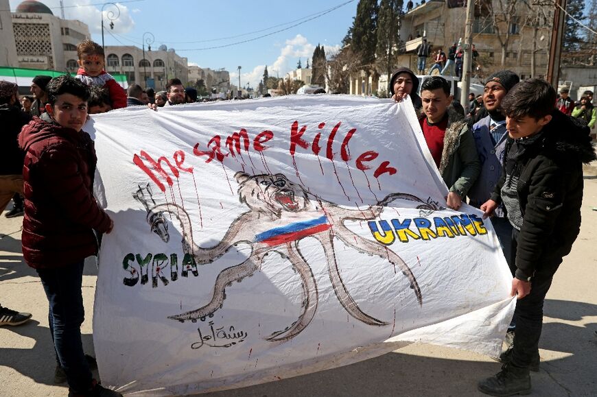 Syrians hold a banner expressing solidarity with the Ukrainian people at the rally in Idlib