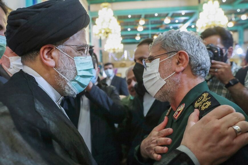 Iran's President Ebrahim Raisi (L) greets the head of the Revolutionary Guards' Quds Force Brigadier General Esmail Qaani at a Tehran ceremony to honour the families of those killed in the 1980-1988 Iran-Iraq war and veterans of that conflict