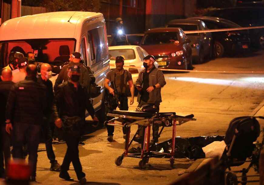 Israeli security forces and emergency personnel gather at the scene of a shooting attack on March 29, 2022 in Bnei Brak, east of Tel Aviv
