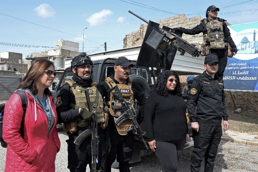 Tourists pose for a picture with Iraqi security forces in the northern Iraqi city of Mosul