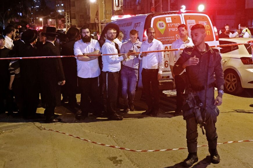 Israeli security forces and civilians gather at the scene of a shooting attack on March 29, 2022 in Bnei Brak