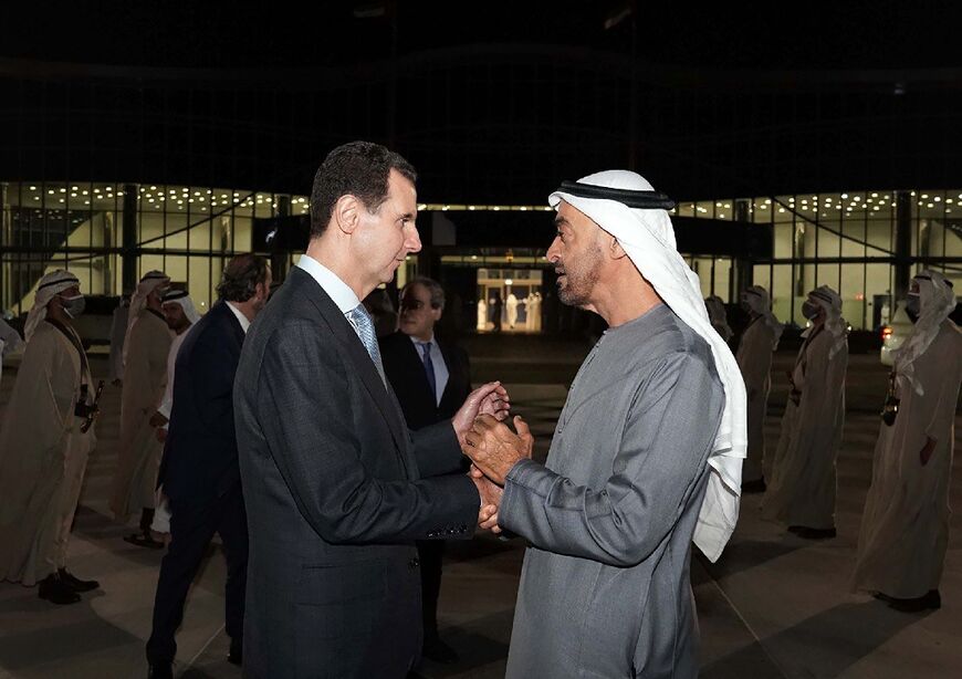 A handout picture released by the Syrian Presidency Facebook page on March 18, 2022 shows Syria's President Bashar al-Assad (L) being greeted by the UAE's de facto ruler Sheikh Mohammed bin Zayed Al-Nahyan in Abu Dhabi