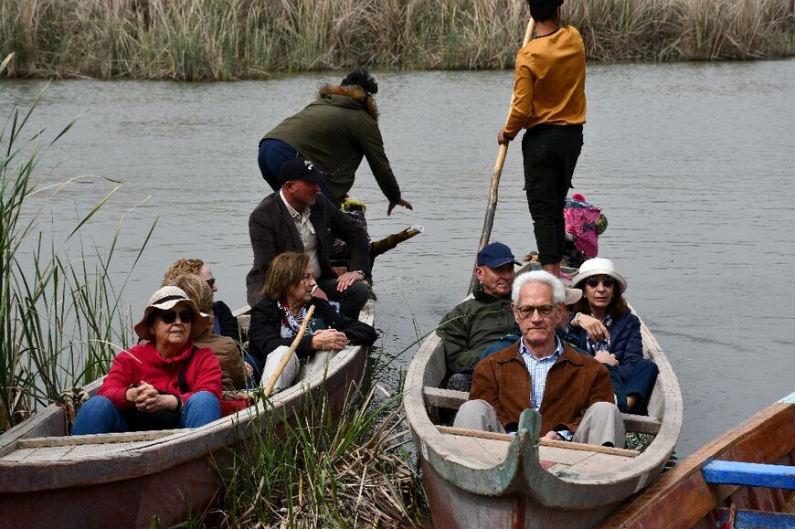 Spanish visitors of the marshes of Jabayesh in southern Iraq ride boats as they tour the area
