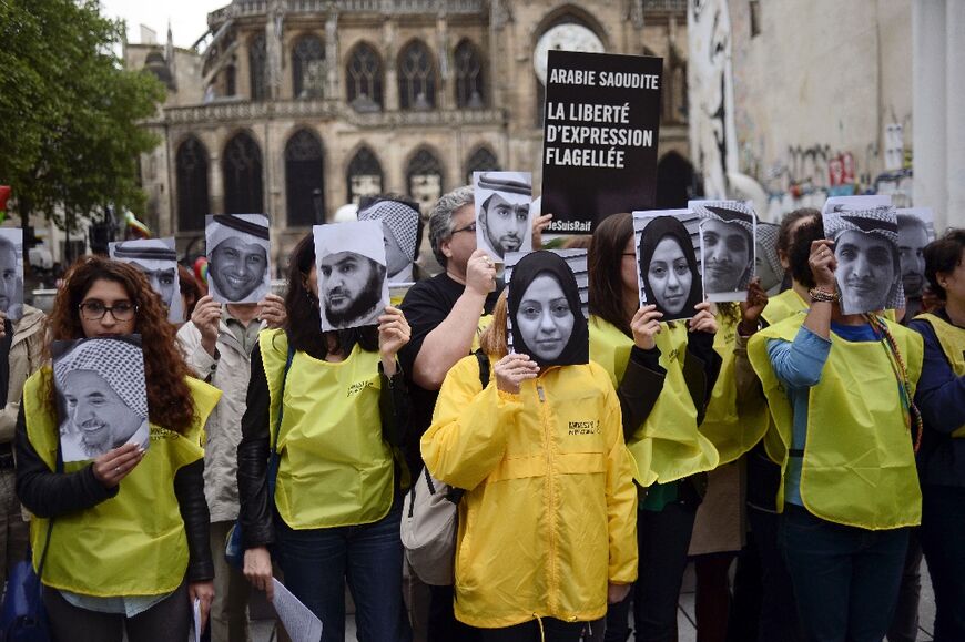 Demonstrators hold pictures of Saudi blogger Raif Badawi and his sister Samar at a rally for their release in Paris in 2015