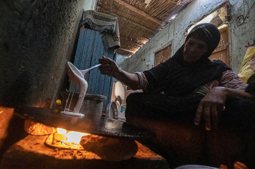 Umm Abdo prepares bread for the family in her home at Zerzara village on the west bank of the Nile river, off Egypt's southern city of Aswan