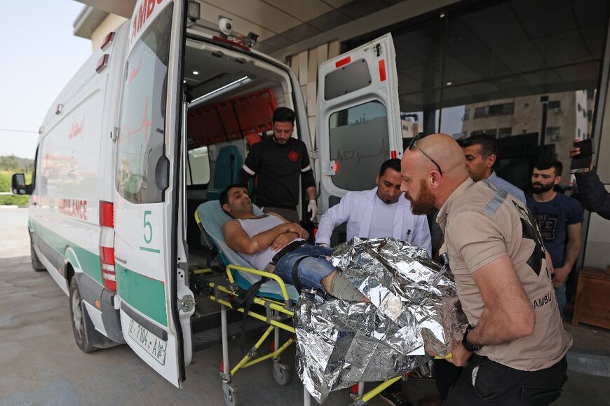 Paramedics transport a wounded Palestinian man after he was shot while trying to cross into Israeli areas near the West bank town of Jenin, on April 18