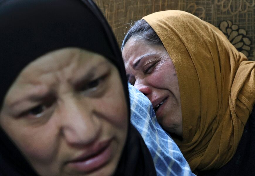 The mother of Palestinian Mohammed Ghnaim (R) is comforted during his funeral in al-Khader village near Bethlehem city in the occupied West Bank, on April 11, 2022, a day after the Israeli army shot him dead, saying he had thrown a Molotov cocktail