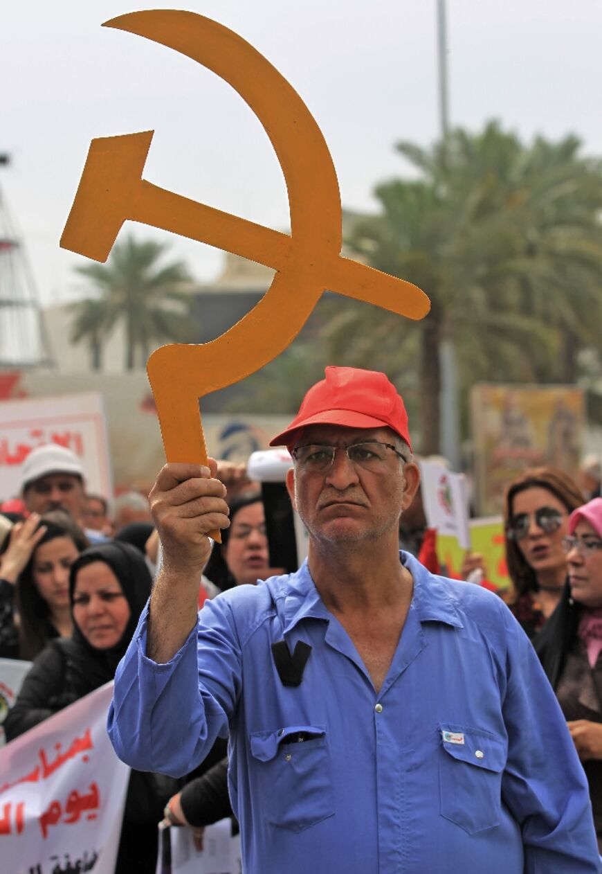 A supporter of the Iraqi Communist Party holds up a hammer and sickle cut out, a symbol of communism, during a rally marking Labour Day in the capital Baghdad May 1, 2019
