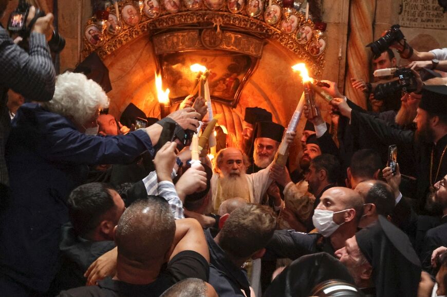 Greek Orthodox Patriarch of Jerusalem Theophilos III holds candles as the faithful gather for the Holy Fire ceremony in the Church of the Holy Sepulchre, which they believe to be the burial place of Jesus Christ