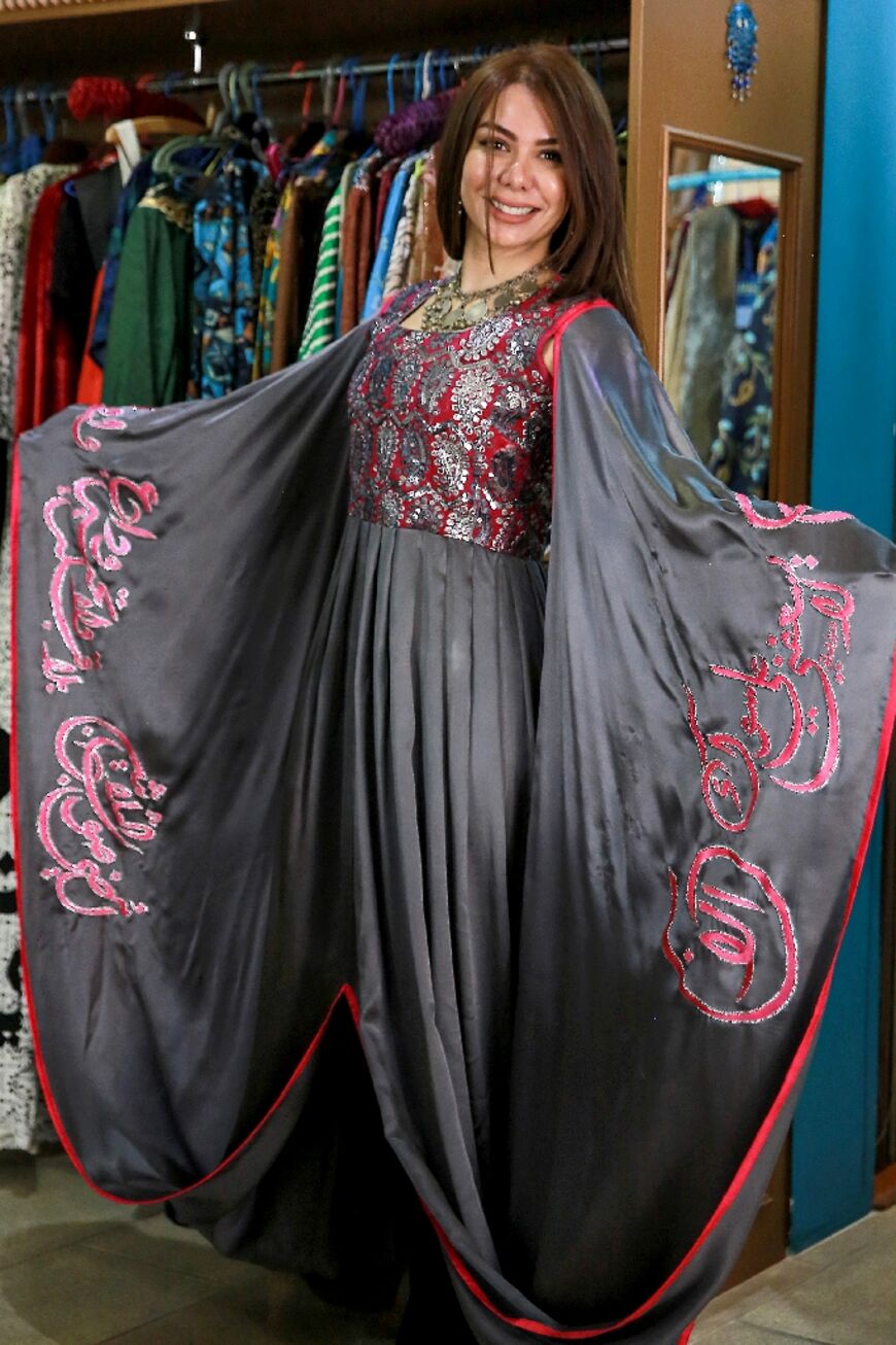 A model presents a piece by Hana Sadiq, incorporating Arabic calligraphy in the "Diwani" script, at her store in the capital Amman 