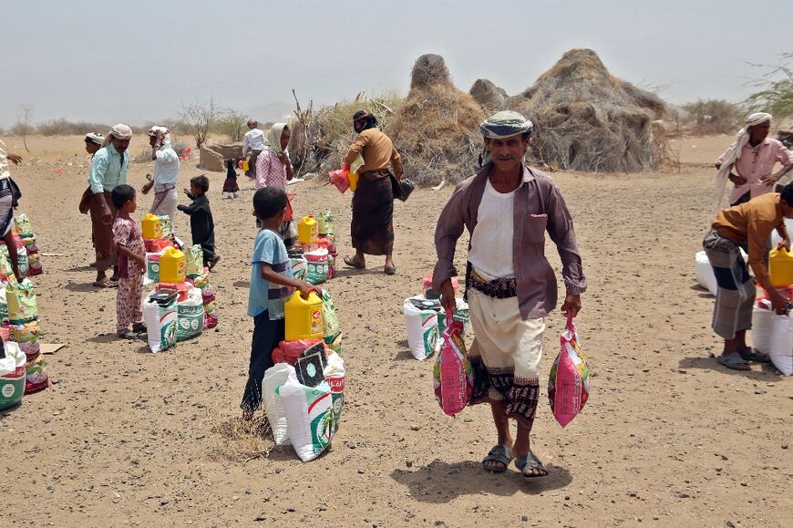 Yemenis displaced by the conflict receive food aid and supplies at a camp in Hays district in the war-ravaged western province of Hodeidah on March 29, 2022